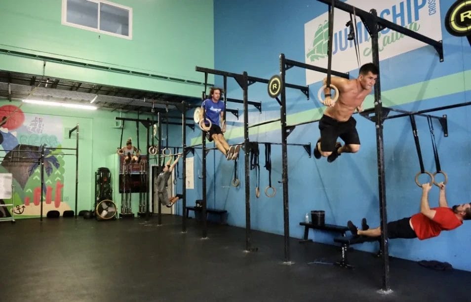 Group of people performing CrossFit ring exercises at Jump Ship Kailua gym